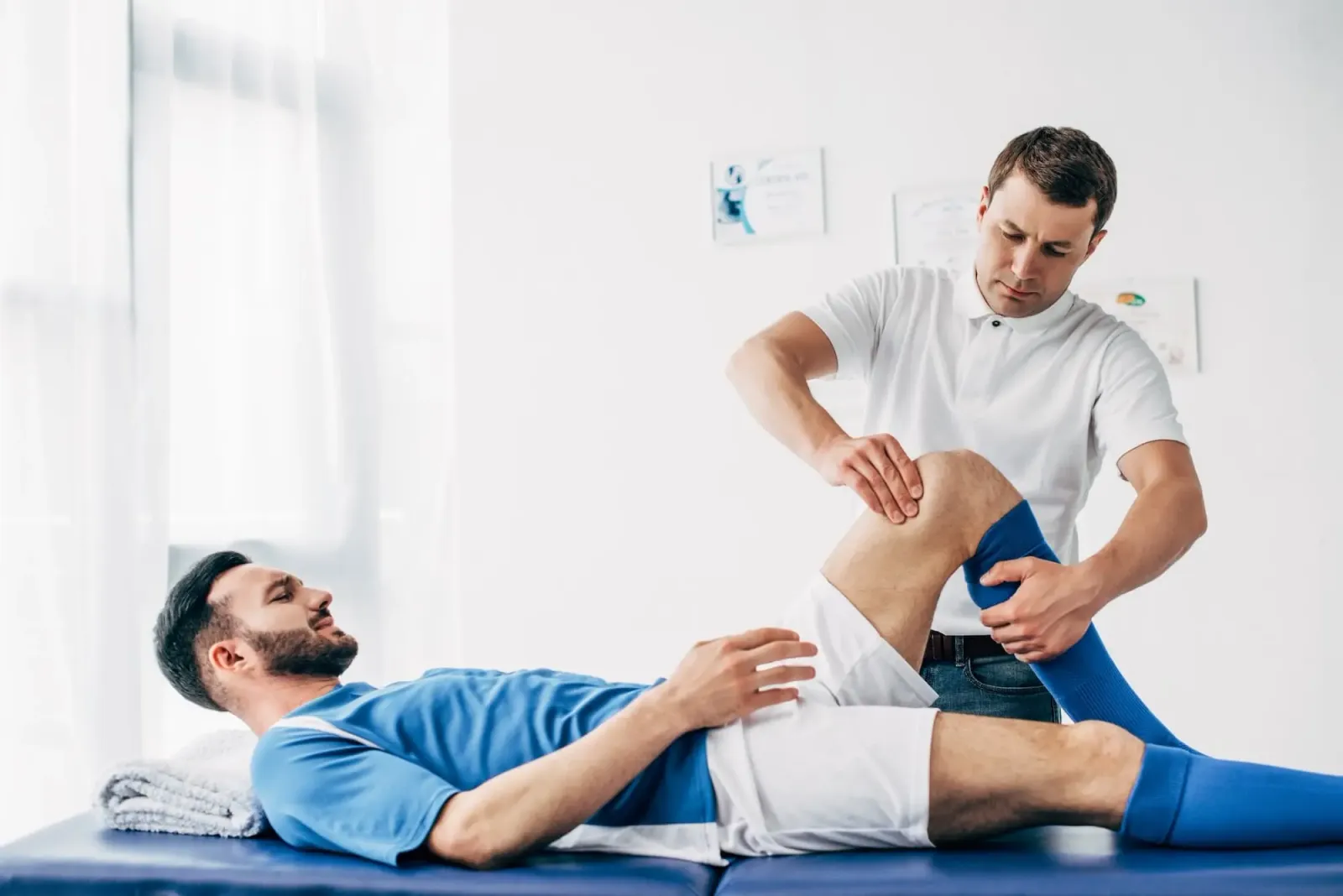 physiotherapist-massaging-leg-of-football-player-l-2022-12-16-16-17-01-utc Physiotherapist Massaging Leg Of Football Player L 2022 12 16 16 17 01 Utc