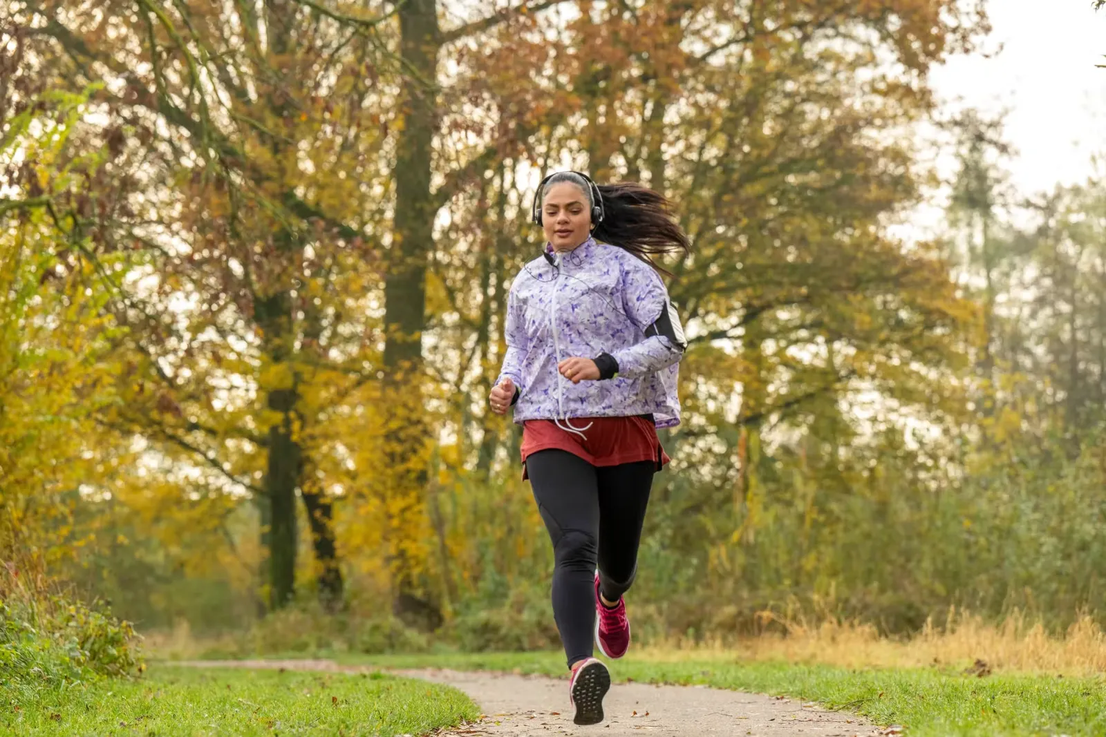 healthy fit woman running through the park keeping 2026 01 09 08 38 00 utc